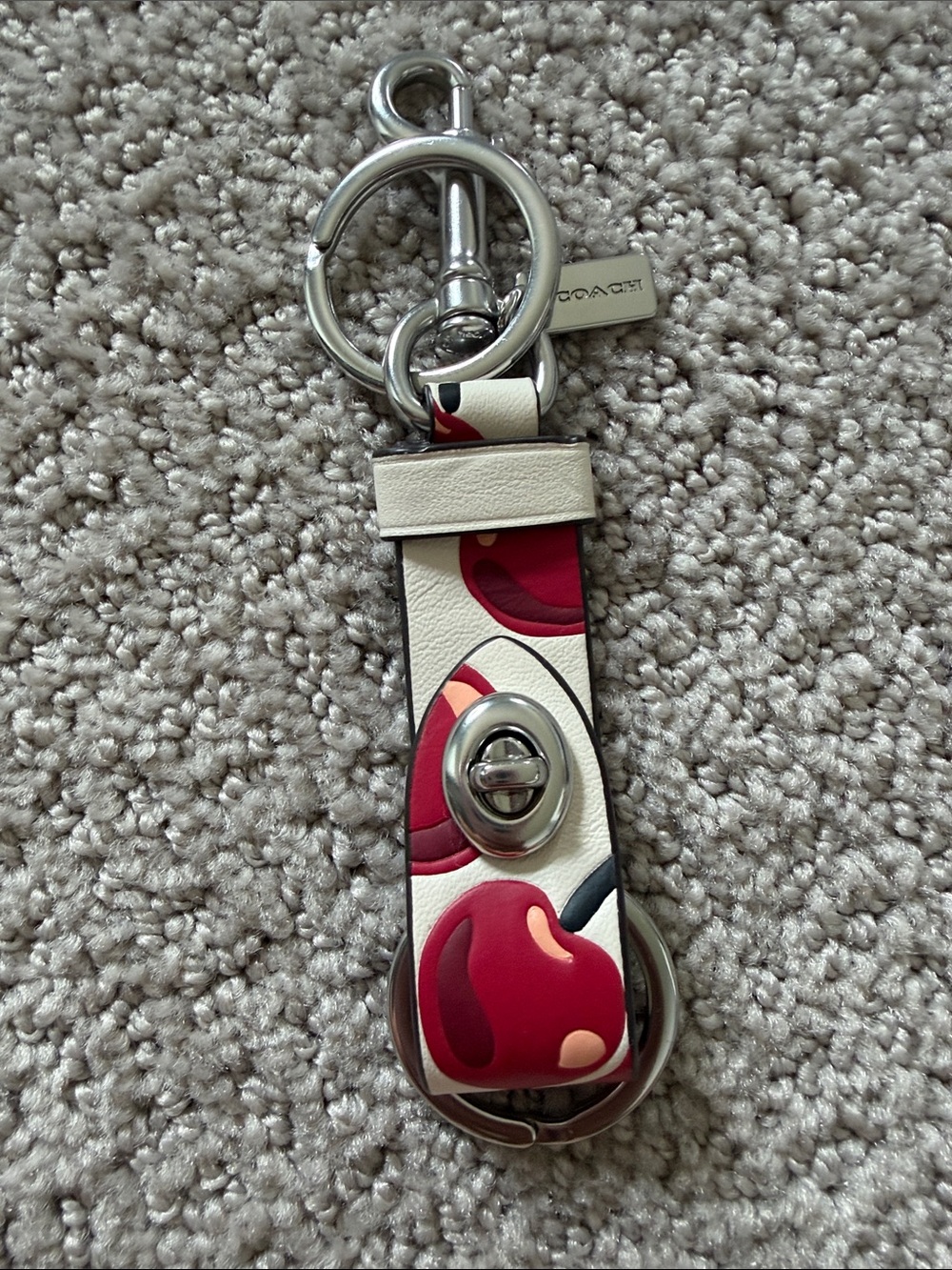 New Coach Trigger Snap Bag Charm with a Cherry Print in Chalk White.